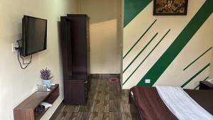 a bedroom with a bed and a flat screen tv at Coorg Annu Stay in Madikeri