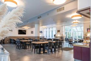 a dining room with tables and chairs in a restaurant at Astoria Hotel Essen in Essen