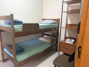 a room with three bunk beds and a desk at Pousada SMART AIRPORT 10 min GRU in Guarulhos