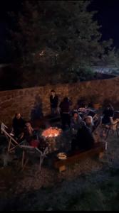 Eine Gruppe von Menschen sitzt nachts um ein Lagerfeuer. in der Unterkunft Shgedi Mestia in Mestia