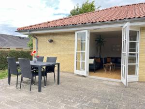 a patio with a table and chairs and a house at Bright and quiet townhouse in Bellinge