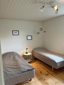 a bedroom with two beds and a table with a lamp at Bright and quiet townhouse in Bellinge