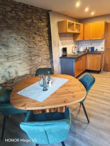 a wooden table with blue chairs and a kitchen at Ferienwohnung Bahnhof Ehr in Halsenbach