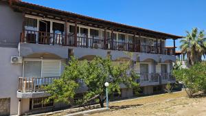 a large apartment building with balconies and trees at Sithonia Mare Hotel in Gerakini