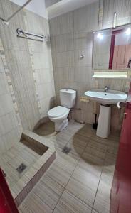 a bathroom with a toilet and a sink at Sithonia Mare Hotel in Gerakini