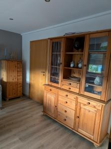 a large wooden cabinet with glass doors in a room at Ferienwohnung Bahnhof Ehr in Halsenbach