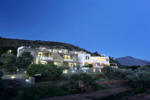 un gran edificio por la noche con las luces encendidas en Aithra -Agios Petros Andros, en Gavrion