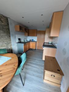 a kitchen with wooden cabinets and a wooden table at Ferienwohnung Bahnhof Ehr in Halsenbach