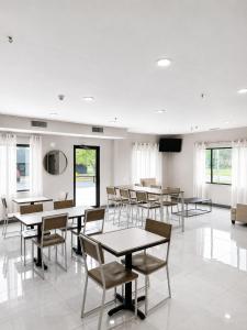 a dining room with tables and chairs and windows at Sleep Inn & Suites Peoria North in Peoria