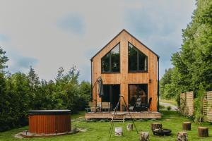 ein kleines Holzhaus mitten in einem Hof in der Unterkunft Otuli in Ćmińsk