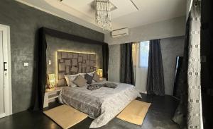 a bedroom with a large bed and a chandelier at Prestige Majorelle Résidence Prestige Majorelle in Ngaparou +15 photos