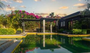 a house with a swimming pool and flowers at Prestige Majorelle Résidence Prestige Majorelle in Ngaparou