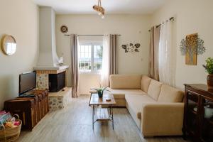 a living room with a couch and a tv at Mareliva Retreat in Trinísia