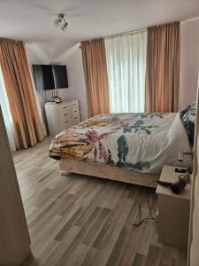 a bedroom with a bed and a wooden floor at Vila Pângărați in Pangarati