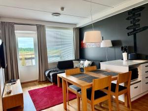 a living room with a table and a couch at Chalet in Vierumäki with golf course view in Lahti
