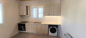 a small kitchen with a washer and dryer in it at Sun & Stones Suite in Agrari +8 photos