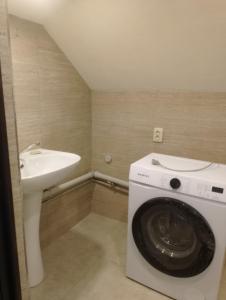 a washing machine in a bathroom with a sink at Hotel Nia in Ureki