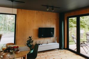 ein Wohnzimmer mit einem Fernseher an der Wand in der Unterkunft Otuli in Ćmińsk