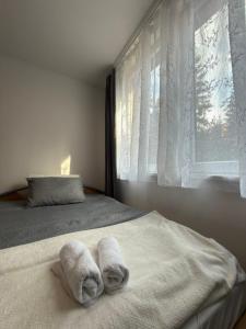 a bedroom with towels on a bed with a window at Valverde Apartment Vlašić in Šišava