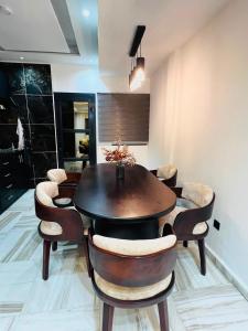 a dining room with a wooden table and chairs at Mandys Guest House in Yaoundé
