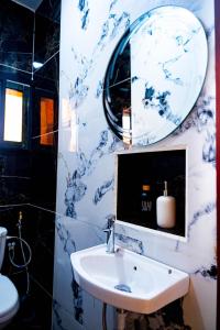 a blue and white bathroom with a sink and a mirror at Mandys Guest House in Yaoundé