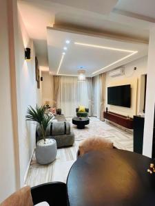 a large living room with a couch and a tv at Mandys Guest House in Yaoundé