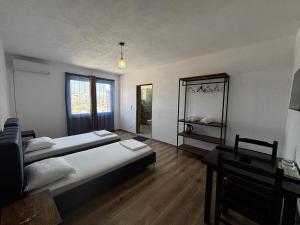 a bedroom with two beds and a table and window at ARBI GUEST House in Kukës +52 photos