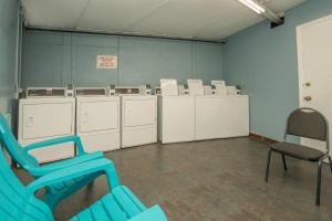 a room with a row of washing machines and a chair at Olde Gatlinburg Rentals in Gatlinburg