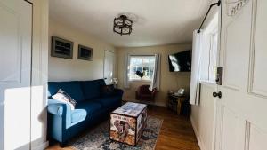 a living room with a blue couch and a window at The Cottage on the Farm in Ladysmith