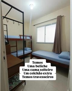 a room with two bunk beds and a sign that reads teminusumeumeume at Apartamento Castelhanos Anchieta in Anchieta