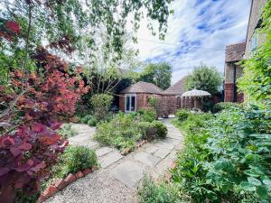 a garden in front of a brick house at The Willow Nest in Hambleden