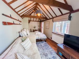 a living room with two beds and a flat screen tv at The Willow Nest in Hambleden