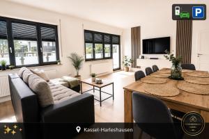 a living room with a table and a couch at Ferienwohnung Kassel mit Ladesäule & Balkon in Kassel