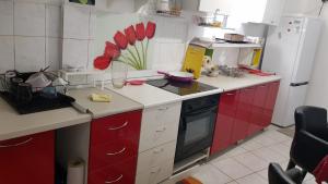 a kitchen with red and white cabinets and a refrigerator at Katata Apartment One -Bedrom in Podgorica +3 photos