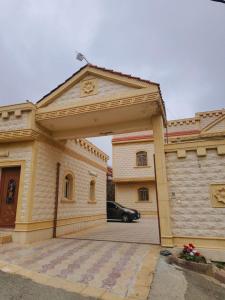a building with a car parked in a parking lot at شقق ضوء القمر Moonlight Apartment in Rahwat al Barr