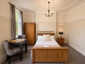a bedroom with a bed and a desk and a chair at 55 Studio 1 Uplands in Swansea