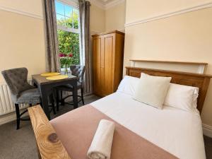a bedroom with a bed and a table and a window at 55 Studio 1 Uplands in Swansea +3 photos