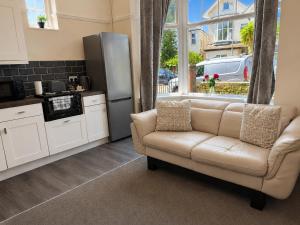 a living room with a couch and a refrigerator at 55 Studio 1 Uplands in Swansea