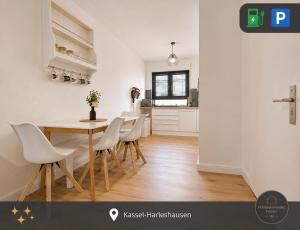 a kitchen and dining room with a table and chairs at Ferienwohnung Kassel mit Ladesäule & Balkon in Kassel