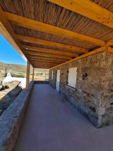 a brick building with a wooden roof over a sidewalk at Sun & Stones Suite in Agrari