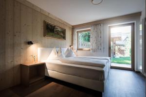 a bedroom with a large bed and a window at Chalet Aldian Dolomites in Selva di Val Gardena