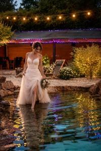 a woman in a wedding dress standing in the water at Hostinec U Rypáka in Vrátkov