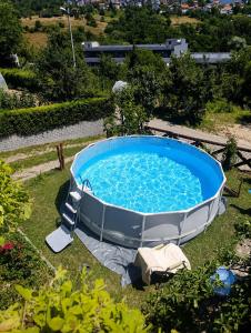 a hot tub in the grass with blue water at Kavkaz Apartment in Sarajevo