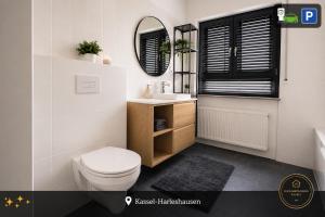 a bathroom with a toilet and a sink and a mirror at Ferienwohnung Kassel mit Ladesäule & Balkon in Kassel