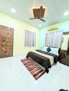 a bedroom with a bed and a ceiling fan at Indraprastha villa in Malavli
