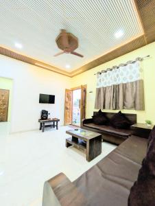 a living room with a couch and a table at Indraprastha villa in Malavli