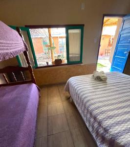 a bedroom with a bed and a window at Hostal Humahuaca in Humahuaca