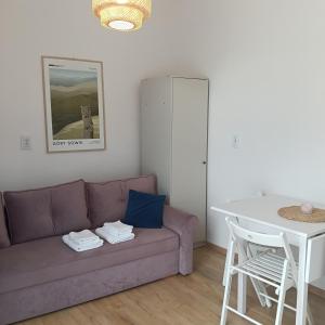 a living room with a purple couch and a table at Sowia Dziupla in Zagórze Śląskie