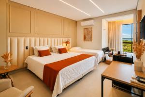 a hotel room with two beds and a television at Pousada com piscina, jacuzzi e com vista em Capitólio - Casa Decore in Capitólio