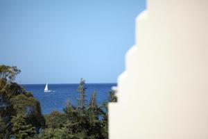 a sailboat in the water with a lighthouse at Aithra -Agios Petros Andros in Gavrio